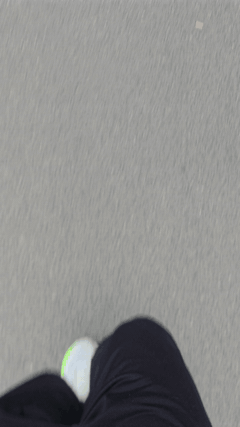 Blick nach unten auf die eigenen Beine und Laufschuhe beim Laufen